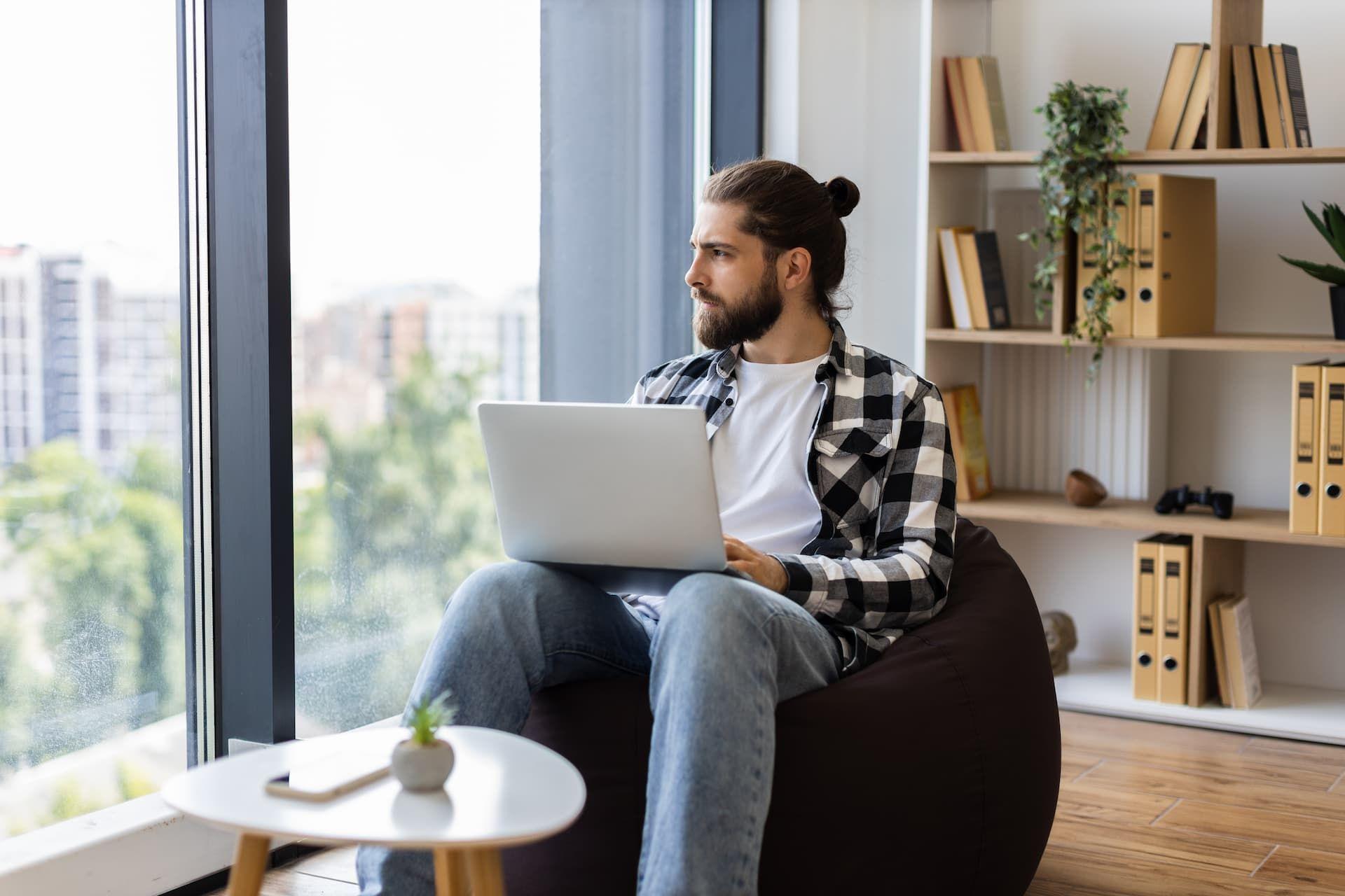 freelancer working from his computer looking out the window