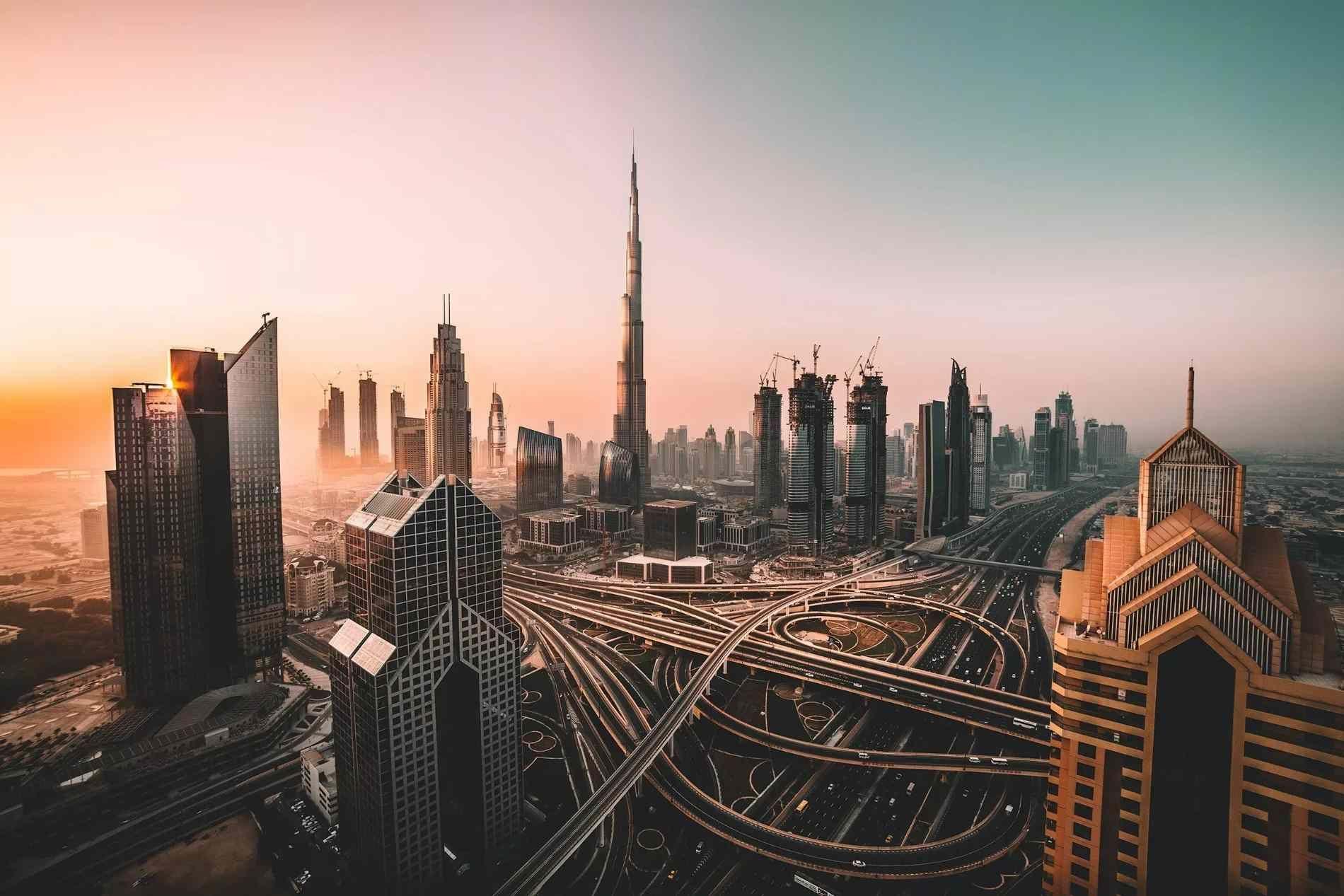 Aerial view of Dubai skyline with the Burj Khalifa and surrounding highways.
