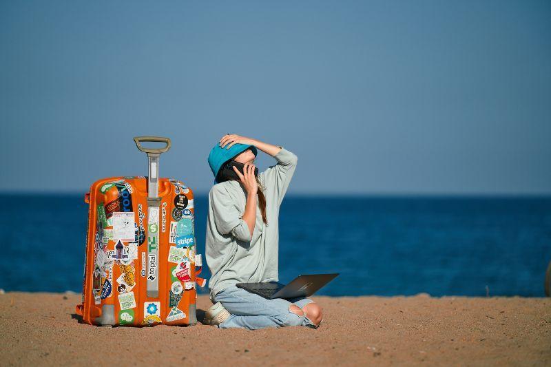 Freelancer with luggage and laptop planning the best countries to move to from UK.