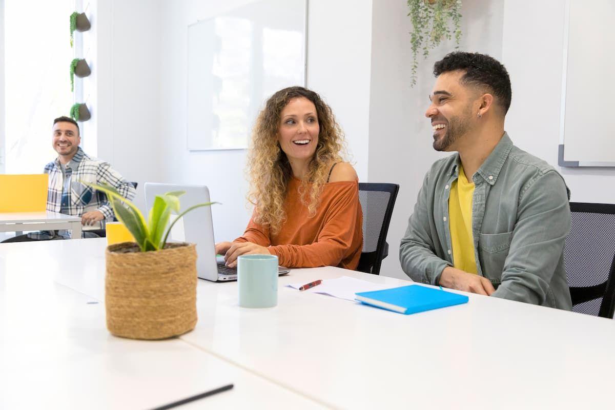 Three people talking happily in an office