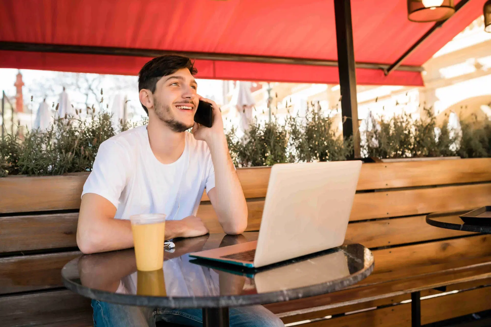 man chatting on phone at cafe table