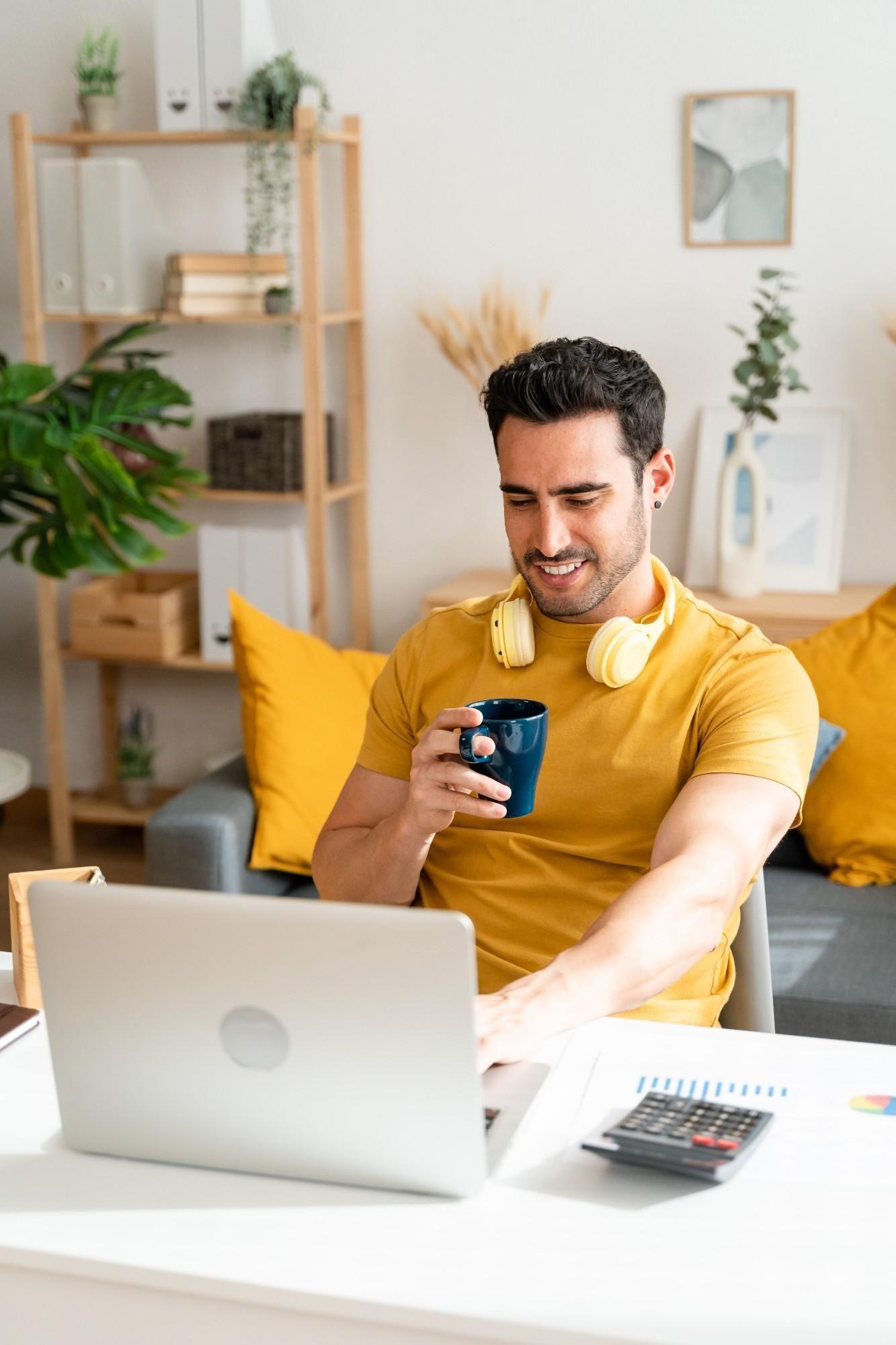 Freelancer working from home on a laptop while enjoying a cup of coffee.