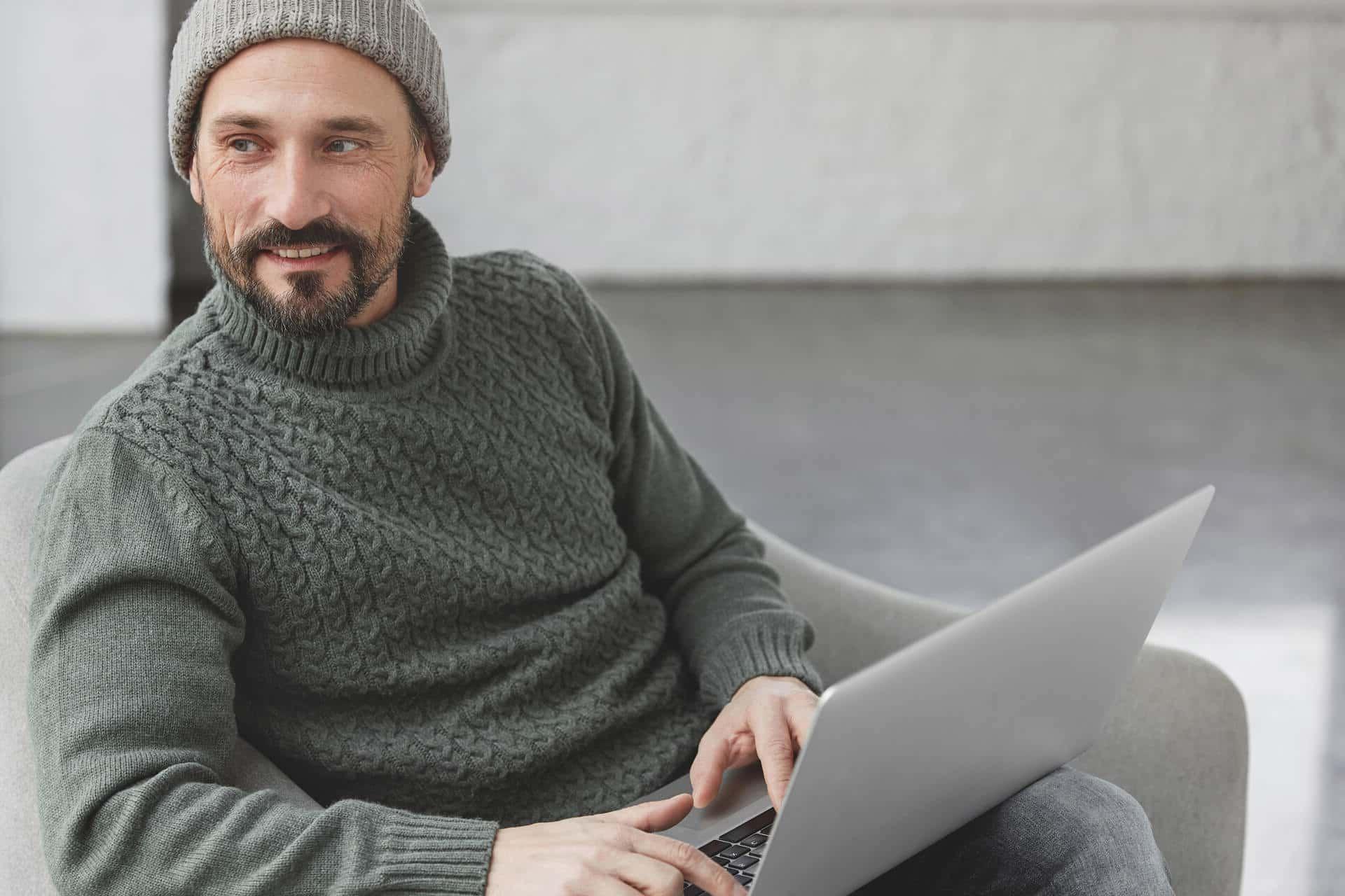 Freelancer working from his sofa, comfortable and in a minimalist setting