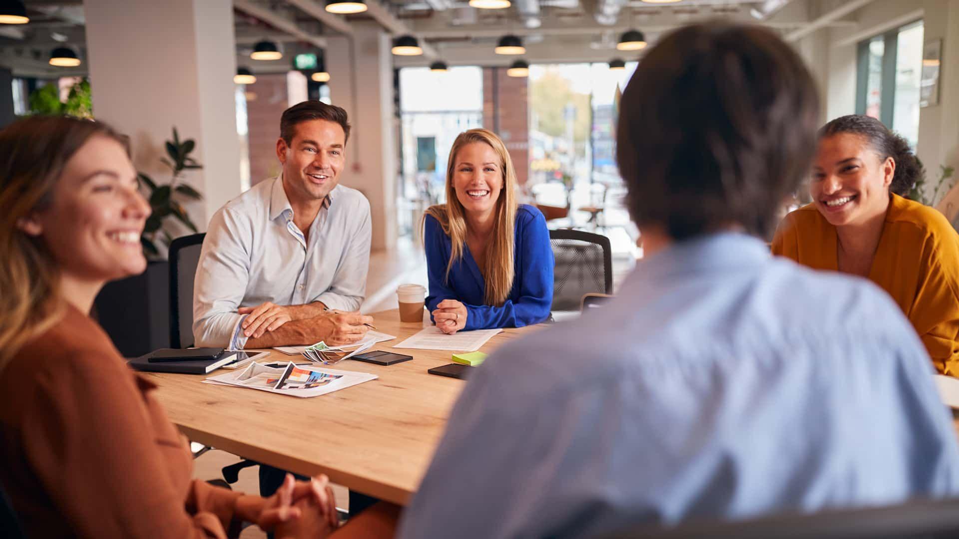 Five happy people at a business meeting