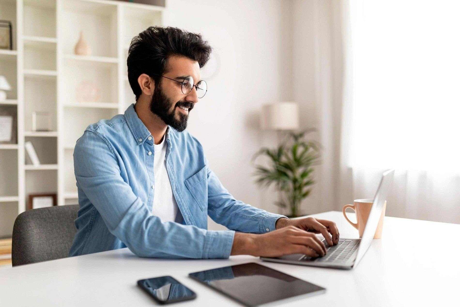Freelancer working on a laptop from a bright home office.