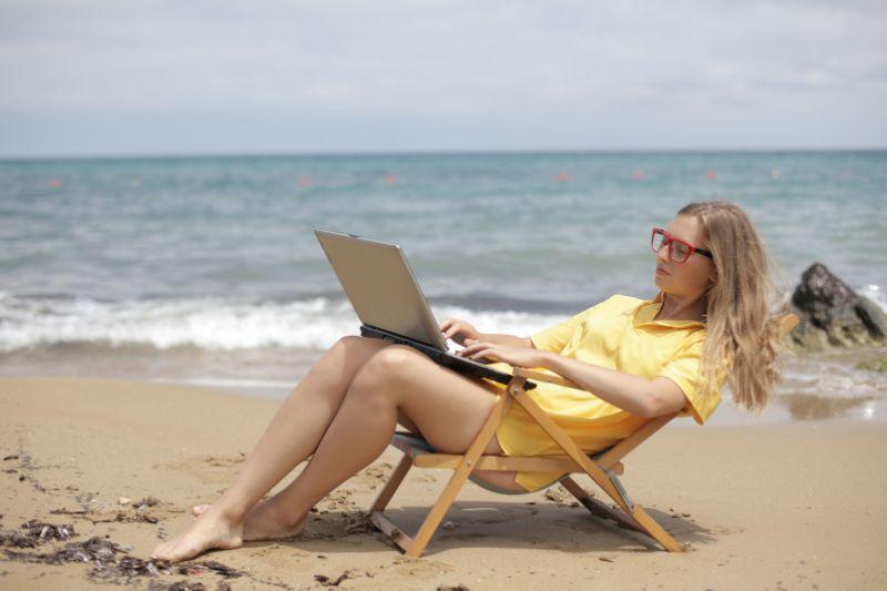 Contractor working remotely from a beach illustrating umbrella company holiday pay.