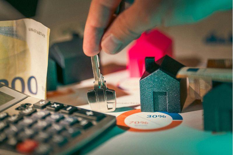 Visualising umbrella company mortgage planning using house models, keys, and financial documents