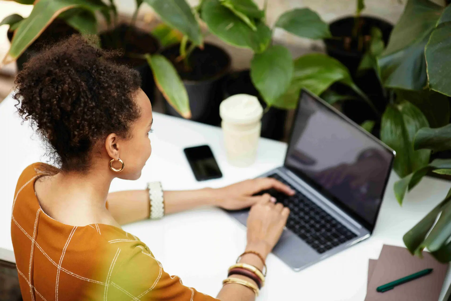 woman working at desk surrounded by plants